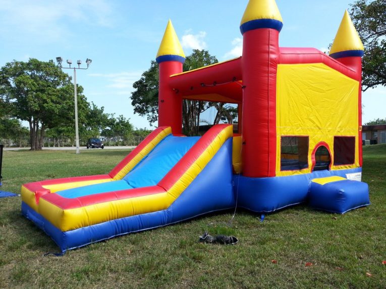 Bounce house and slide set up on grass
