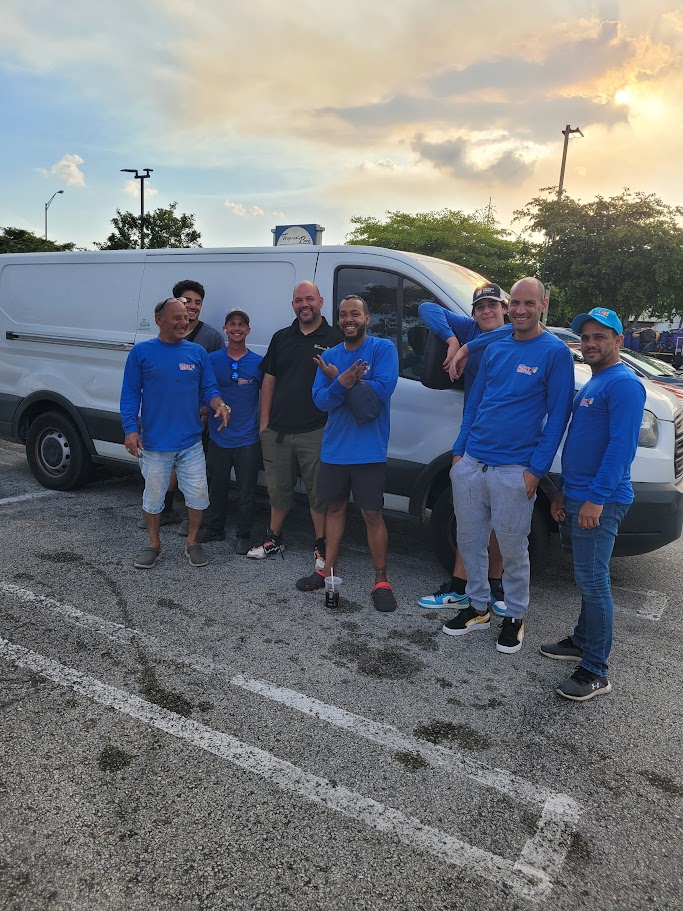 Members of the Mom’s Party Rental team standing beside a delivery van